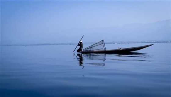 A fisherman prepares to spear for fish Nov. 9 in the shallow waters of Myanmar's Inle Lake. The massive freshwater lake, ringed by picturesque mountain ranges, is a major tourist hub in the military-ruled state. Tour operators are hoping for a bumper year following the release of pro-democracy leader Aung San Suu Kyi last November. 